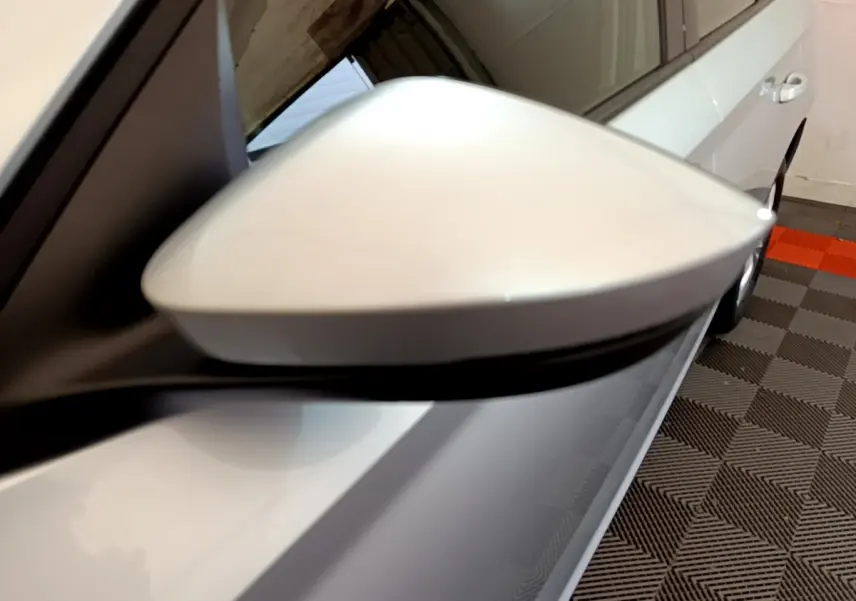 Gros plan sur le rétroviseur droit gris clair du Skoda Kamiq 2022, avec la portière et une partie de la roue visibles.