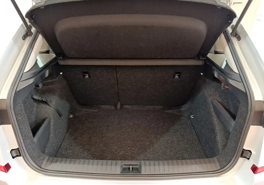 Coffre ouvert d'une SKODA KAMIQ gris clair vu de l'arrière, montrant un espace de chargement propre et spacieux.