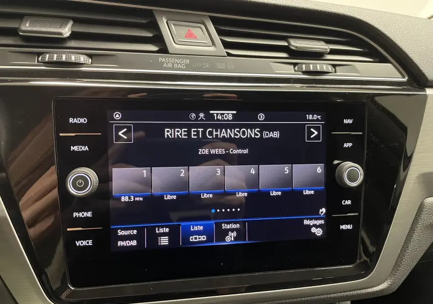 Écran tactile central du tableau de bord du Volkswagen Touran 2024 affichant la radio numérique Rire et Chansons.