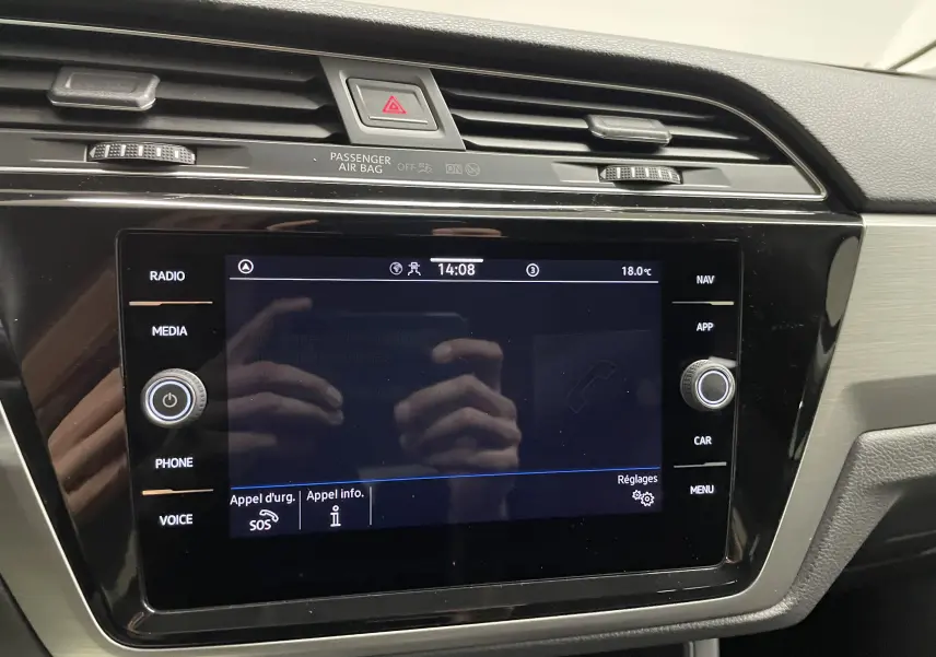 Écran tactile central du tableau de bord du Volkswagen Touran 2024, avec commandes radio, média et navigation visibles.