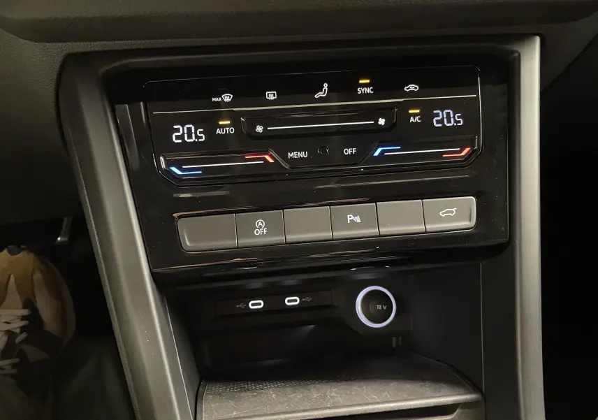 Vue rapprochée de la console centrale du Volkswagen Touran 2024 avec climatisation digitale et commandes de hayon électrique.
