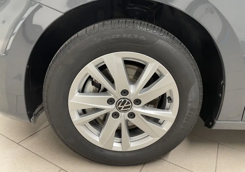 Gros plan sur la roue avant gauche d’un Volkswagen Touran Gris Dauphin avec jante alliage et pneu Pirelli.