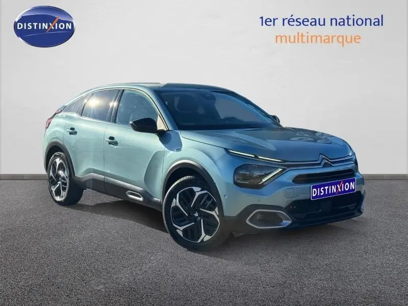 Citroën C4 gris vue 3/4 avant droit, avec signature lumineuse distinctive et jantes modernes.