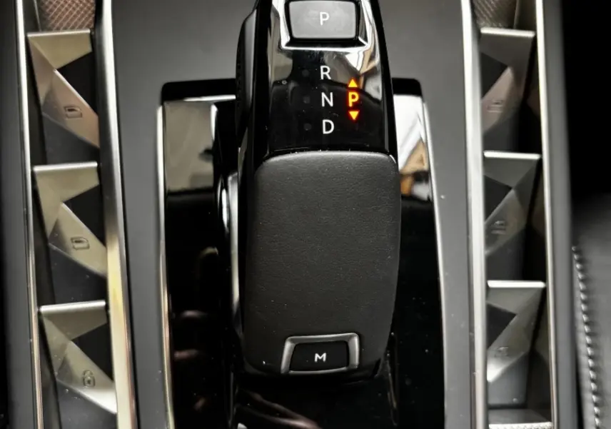 Vue rapprochée du levier de vitesses automatique noir brillant de la DS3 2024 avec commandes latérales en métal brossé.