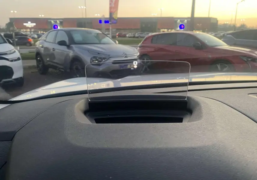 Vue intérieure du tableau de bord de la Citroën C4 blanche 2021 avec affichage tête haute transparent en position relevée.