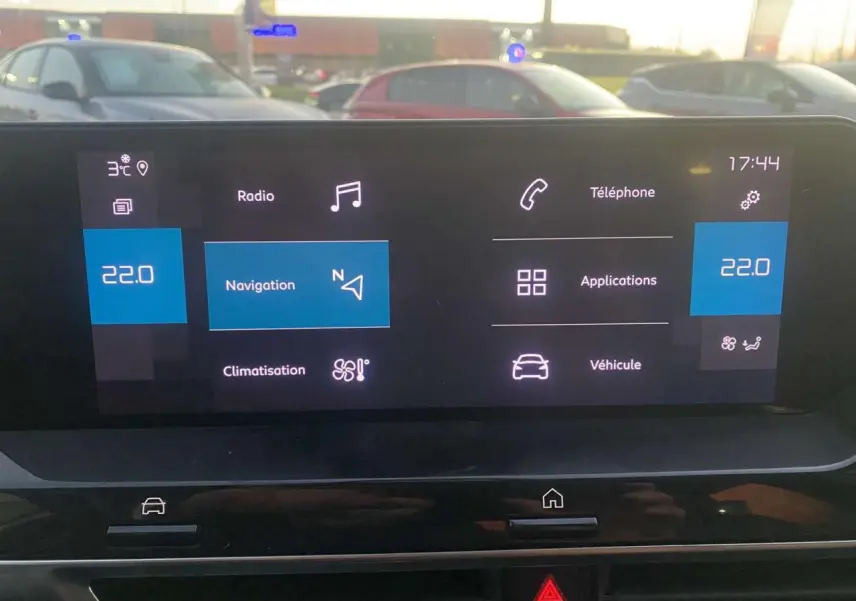 Écran tactile central de la Citroën C4 blanc, affichant la navigation et la climatisation à 22°C, vue intérieure frontale.