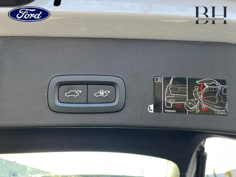 Boutons de commande d'ouverture et de verrouillage du coffre sur la partie intérieure du hayon d'un Volvo XC40 gris Glacier.