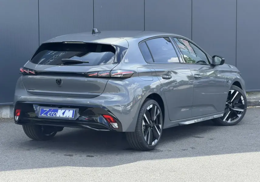 Vue 3/4 arrière droite d'une Peugeot 308 gris Selenium avec jantes bi-tons et feux arrière LED 3 griffes.
