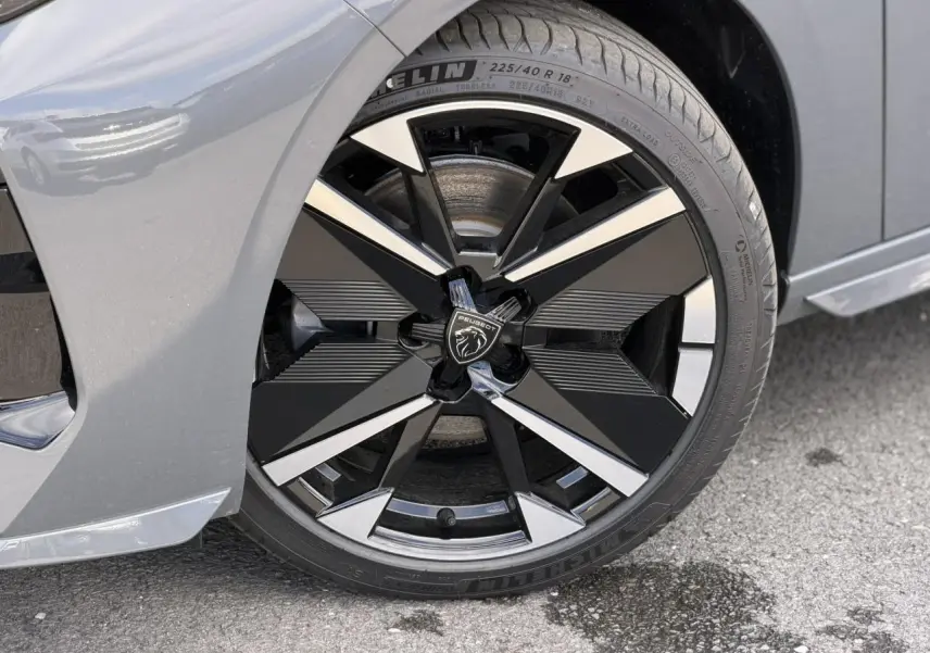 Gros plan sur la jante alliage bi-tons noir et argent de la Peugeot 308 gris Selenium, roue avant côté gauche.