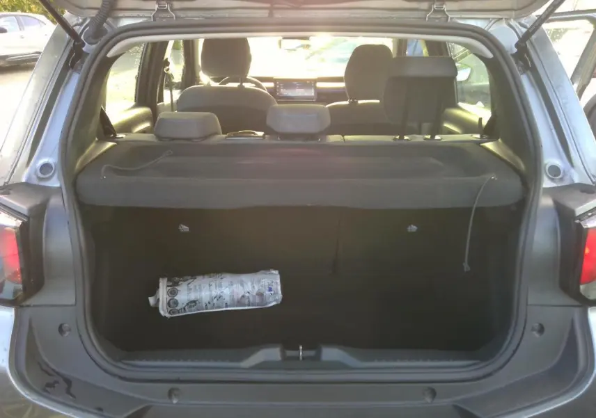 Vue arrière du coffre ouvert d'une Citroën C3 gris foncé, montrant l'espace de chargement et la plage arrière.