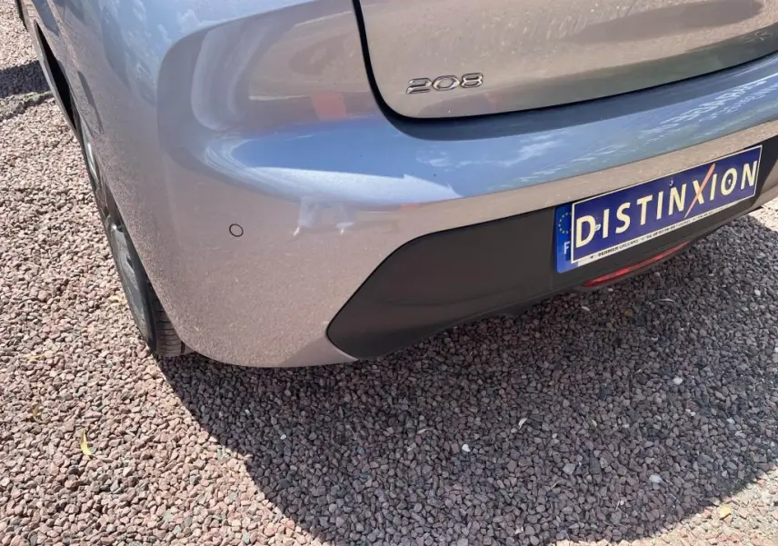Vue arrière côté gauche du Peugeot 208 gris clair 2023 avec logo 208 et plaque d'immatriculation Distinxion.