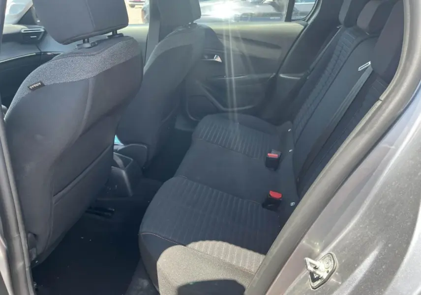 Vue intérieure côté droit montrant la banquette arrière noire de la Peugeot 208 gris clair 2023.