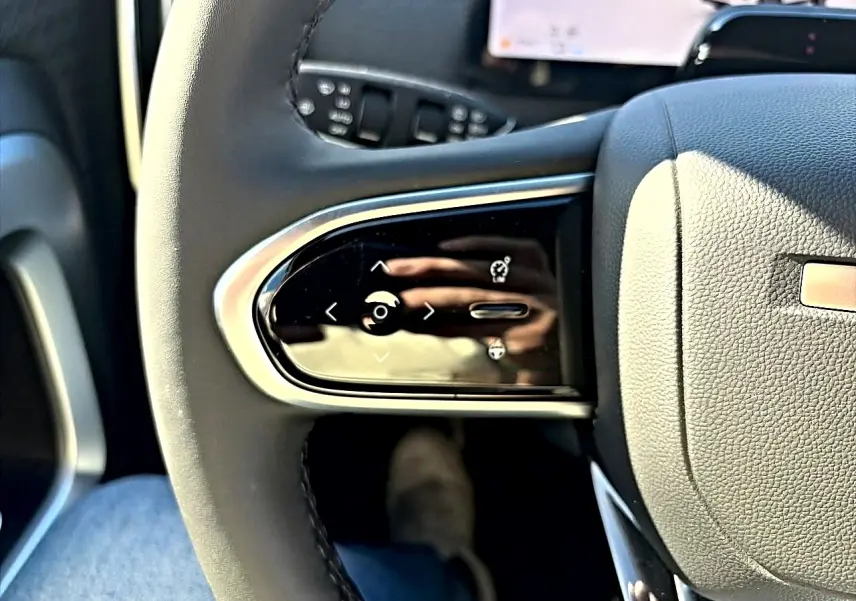 Gros plan sur les commandes multifonctions à gauche du volant noir du JAECOO J7 1.5 tgdi 224 select.