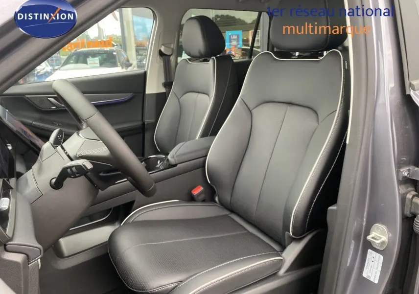 Vue intérieure côté conducteur du JAECOO J5 2026 gris Phantom, sièges cuir noirs avec surpiqûres blanches et volant cuir.