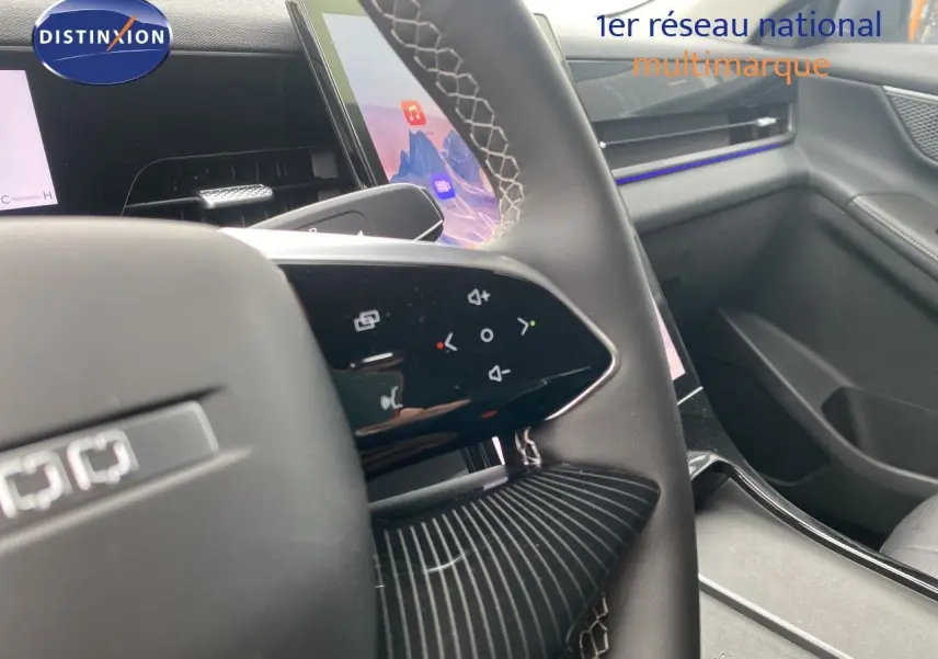 Vue rapprochée du volant cuir noir avec commandes tactiles et partie de la planche de bord intérieure grise du JAECOO J5.