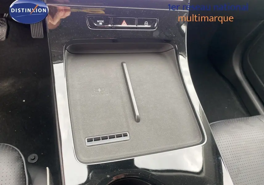 Vue rapprochée de la console centrale du JAECOO J5 1.5 TGDI HEV 165CH BVA en Phantom Grey, avec surface de recharge sans fil.