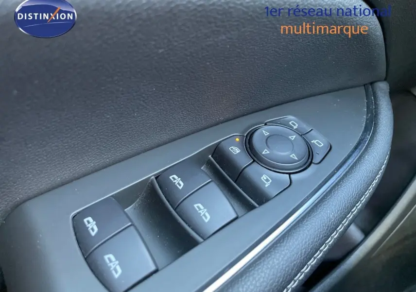 Gros plan sur les commandes des vitres et rétroviseurs côté conducteur d'une Opel Insignia gris minéral métal.