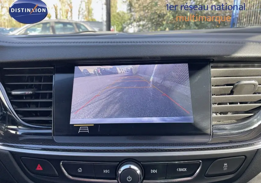 Écran de caméra de recul affichant la vue arrière d'une Opel Insignia gris minéral métal, tableau de bord moderne noir.