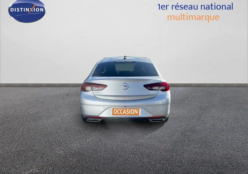 Vue arrière d'une Opel Insignia gris minéral métal de 2021 avec feux LED et double sortie d'échappement visible.