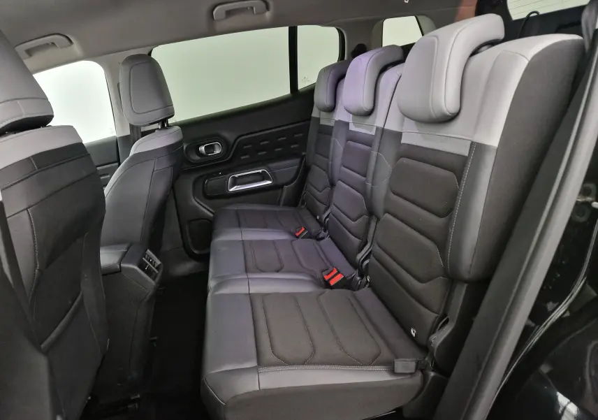 Vue latérale droite de l'intérieur arrière du Citroën C5 Aircross 2024 noir, sièges en tissu bi-ton gris et noir.