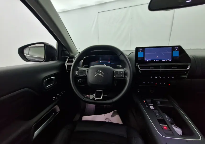 Intérieur noir du Citroën C5 Aircross 2024 vu du siège conducteur, avec tableau de bord numérique et écran central tactile.