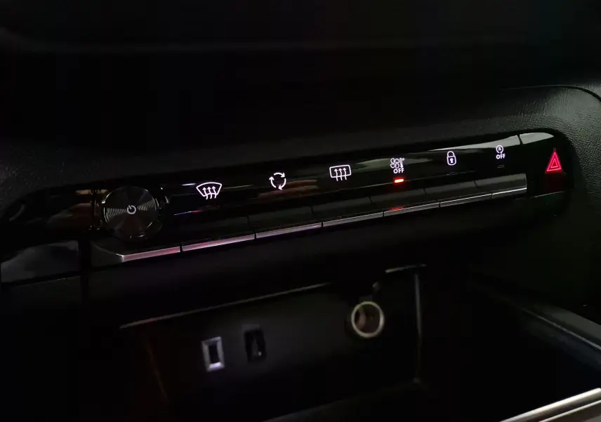 Panneau de commandes climatisation et sécurité intérieur noir du Citroën C5 Aircross 2024 avec boutons lumineux blancs et rouge.