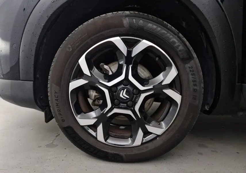 Gros plan sur la jante noire et argentée de 18 pouces Michelin d'un Citroën C5 Aircross noir 2024.