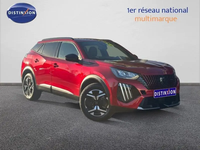 Peugeot 2008 rouge Elixir vue 3/4 avant droit, avec jantes alu et barres de toit noires visibles.