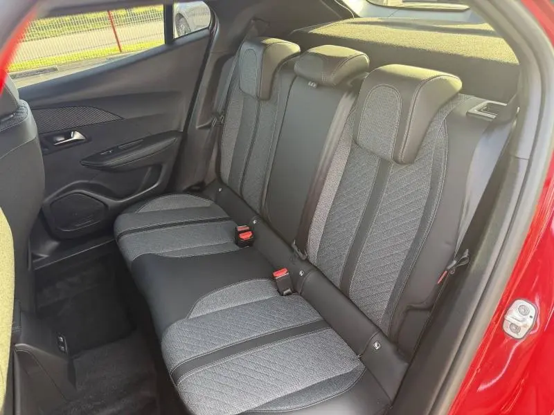 Vue côté droit de la banquette arrière tissu gris et noir du Peugeot 2008 rouge Elixir avec ceinture et appuie-têtes.