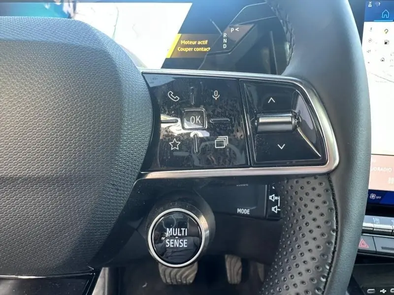 Gros plan sur le volant côté gauche du Renault Austral 2025 Bleu Iron, avec commandes multifonctions et bouton Multi-Sense.