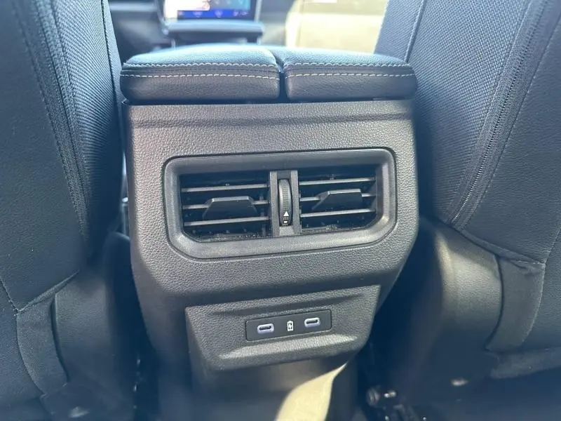 Vue rapprochée des aérateurs arrière et ports USB du Renault Austral 2025, intérieur noir, version hybride Bleu Iron.
