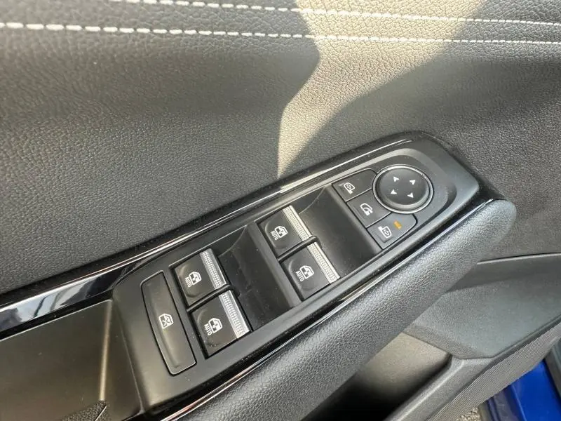 Gros plan sur les commandes des vitres électriques côté conducteur du Renault Austral 2025 en Bleu Iron.