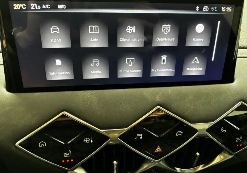Vue rapprochée de l’écran tactile central et des commandes en losange du tableau de bord du DS3 gris clair 2024.