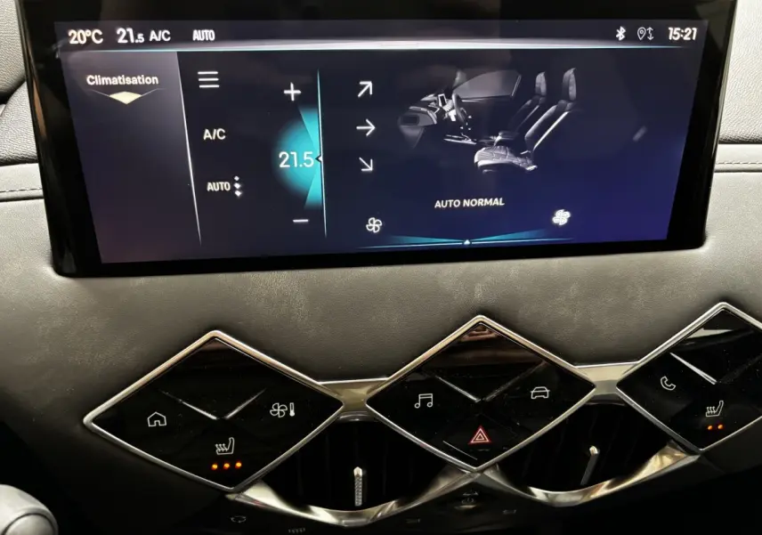 Gros plan sur l'écran tactile central et les commandes de climatisation du tableau de bord du DS3 gris clair 2024.