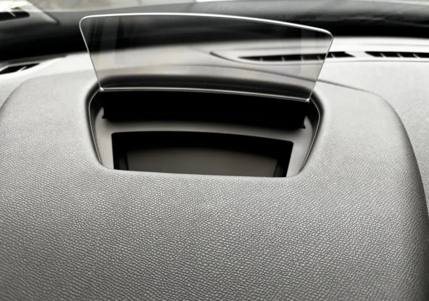 Vue rapprochée du tableau de bord gris foncé du DS3 2024 avec écran tête haute transparent déployé.