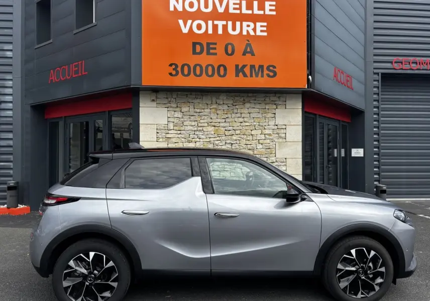 Vue de profil côté gauche d'une DS3 2024 gris clair avec toit noir et jantes alliage noires et argentées.