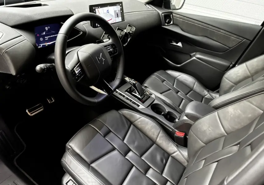 Vue intérieure côté conducteur du DS3 2024 avec sièges cuir noirs, volant multifonctions et écran tactile central.