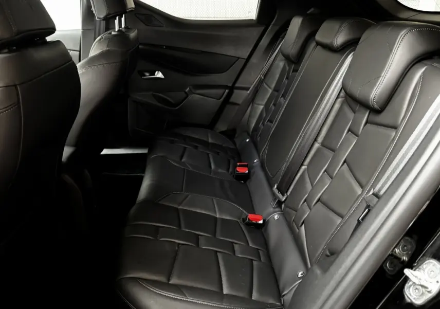Vue intérieure côté droit sur la banquette arrière en cuir noir du DS3 2024, avec ceintures et appuie-têtes visibles.