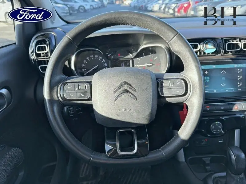 Vue intérieure centrée sur le volant cuir noir du Citroën C3 Aircross 2019 avec commandes intégrées et tableau de bord visible.