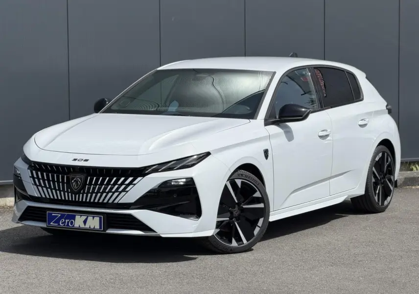 Peugeot 308 NV Hybrid blanc Okenite vue 3/4 avant droit avec jantes noires bi-tons et calandre distinctive.