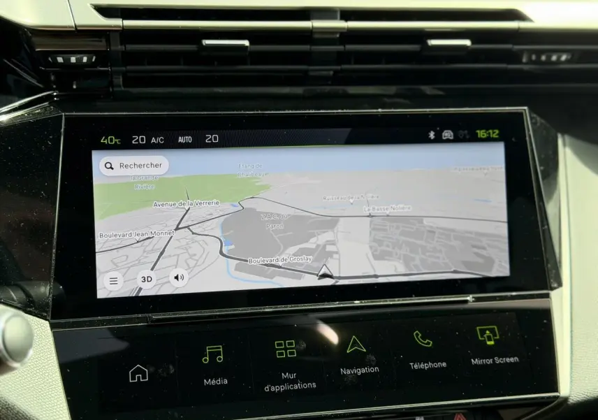 Écran tactile central du tableau de bord de la Peugeot 308 GT hybride, affichant la navigation en mode jour.