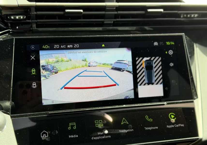 Écran tactile intérieur montrant la caméra de recul et l’aide au stationnement du Peugeot 308 blanc Okenite.