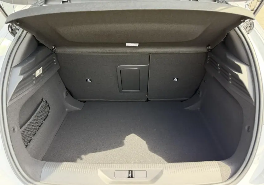 Coffre ouvert vu de l'arrière d'une Peugeot 308 blanc Okenite, espace de chargement propre et bien agencé.