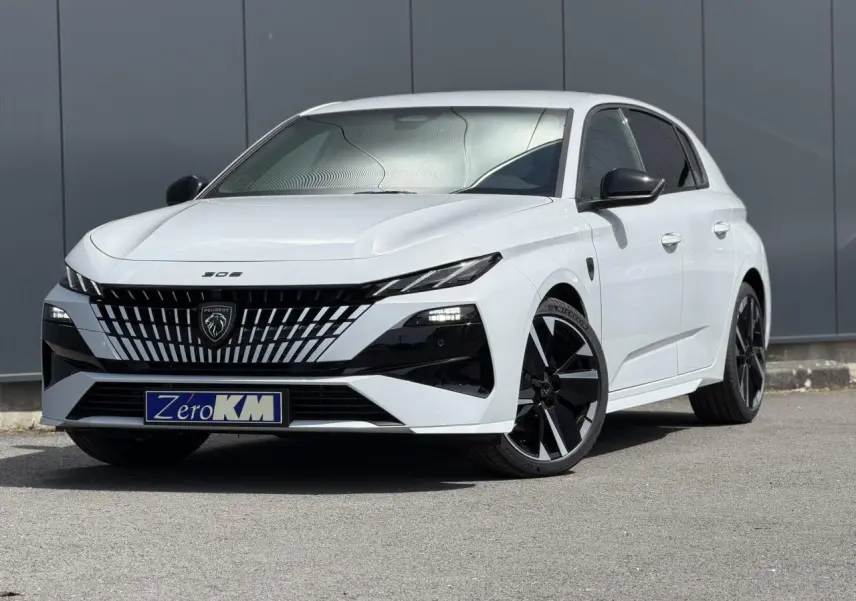 Vue 3/4 avant droite d'une Peugeot 308 blanche Okenite avec calandre noire distinctive et jantes alliage bi-ton.