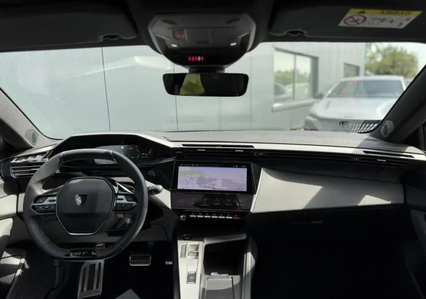 Vue intérieure avant du Peugeot 308 NV Hybrid 145 GT e-DSC6 avec tableau de bord numérique et écran tactile central.