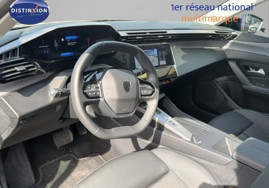 Vue intérieure côté conducteur de la Peugeot 308 Allure Hybrid 145 e-DCS6 avec tableau de bord numérique et volant compact noir.