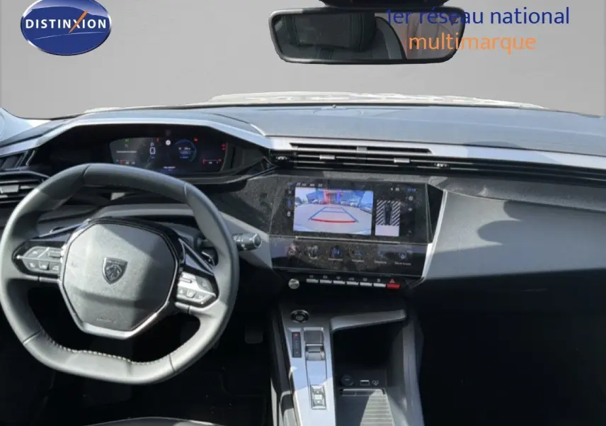 Vue intérieure du tableau de bord et volant de la Peugeot 308 Allure Hybrid 2025 en gris Selenium Metal, écran tactile avec caméra de recul.
