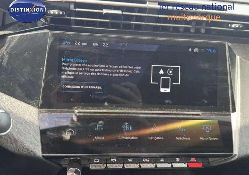 Vue rapprochée de l’écran tactile central du tableau de bord de la Peugeot 308 Allure Hybrid 2025, affichant les options multimédia et climatisation.