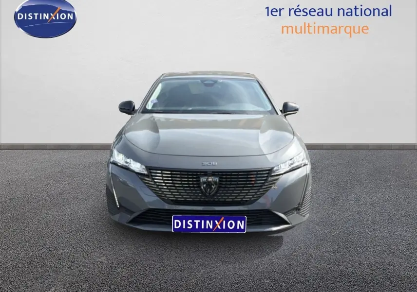Vue frontale d'une Peugeot 308 Allure Hybrid 145 e-DCS6 gris selenium metal, avec calandre noire et phares LED fins.