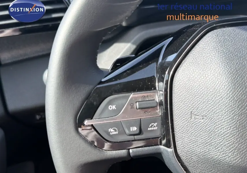 Gros plan sur le volant côté gauche du Peugeot 308 Allure Hybrid 145 e-DCS6 avec commandes intégrées, intérieur noir.